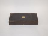 an old wooden box with a brass plate on top of it