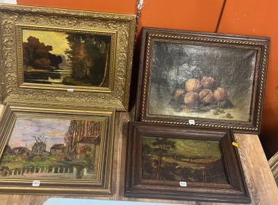 quatre tableaux encadrés posés sur une table dans une pièce
