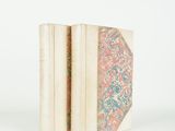 an old book sitting on top of a white table next to a white wall