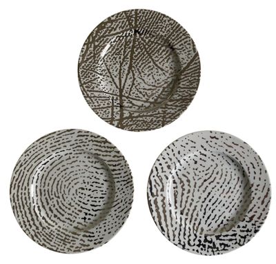 trois assiettes ornées de motifs, posées sur une surface blanche