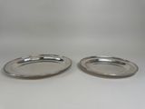 a pair of silver plated dishes on a white background