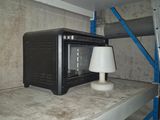 un micro-ondes posé sur une étagère, avec une lampe posée dessus