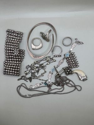 beaucoup de bijoux en argent sur une surface blanche