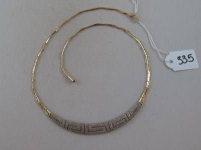 an image of a gold and silver necklace on a white table