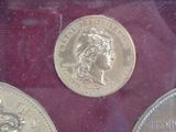 two silver coins sitting next to each other on a red surface
