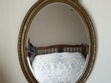 un miroir accroché au mur au-dessus d'un lit dans une chambre