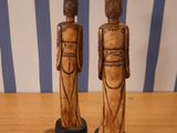 two wooden figurines that are standing on a table