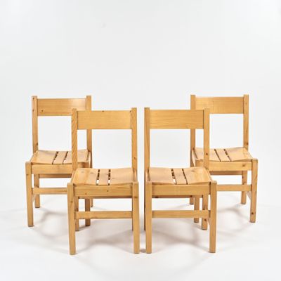 trois chaises en bois assises l'une à côté de l'autre sur une surface blanche