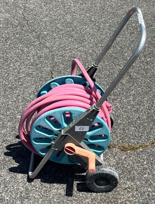 un chariot à tuyaux bleu et rose posé par terre