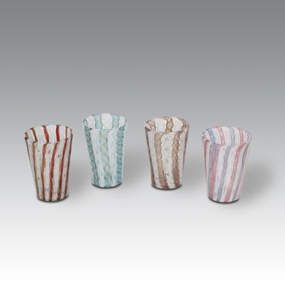 four different colored glass vases sitting next to each other