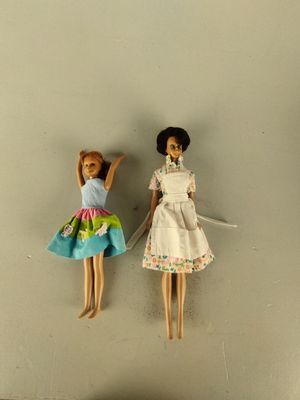 two dolls that are hanging on the wall together