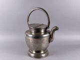 une théière ancienne en argent avec une anse, sur fond blanc