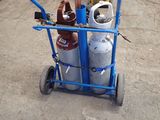 a blue cart with gas bottles on it in a warehouse