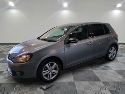 La Volkswagen Golf est garée dans une salle blanche au sol carrelé.