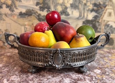 un bol de fruits posé sur une table, avec un canapé en arrière-plan