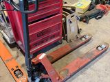 un chariot élévateur dans un garage où des outils sont éparpillés sur le sol