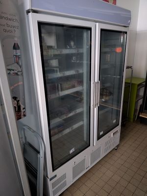 two refrigerators that are sitting in a room