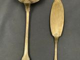two spoons and a spoon rest on a black surface