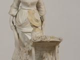 a statue of a woman with a cart of food on a table