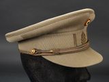 the hat is tan and has a brown ribbon on the side