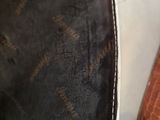 someone is holding the bottom of a black purse with a brown and white pattern