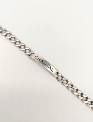 un gros plan d'un bracelet à maillons sur lequel est gravé un prénom