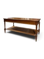Table basse en bois naturel, les pieds fuselés réunis par un…