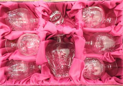a pink box with six glass ornaments inside of it