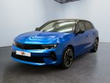 Une voiture bleue est garée dans une grande pièce au sol noir.