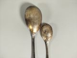 two spoons that are sitting next to each other on a table