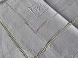 a close up of a white table cloth with a monogram on it