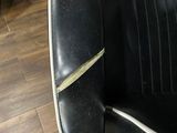 a black leather chair with a white stripe on the seat