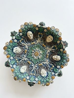 bol en céramique bleu et vert orné de visages et de fleurs