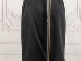black skirt on a mannequin stand in front of a white wall