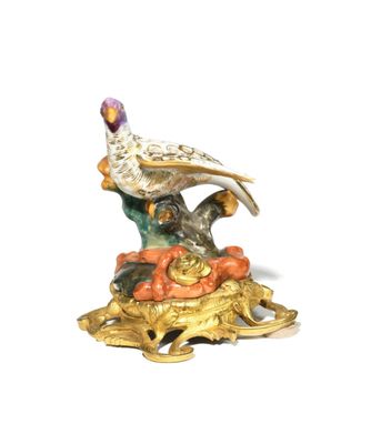 a figurine of a bird sitting on top of a pile of pumpkins