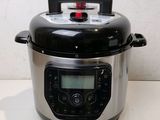 a black and silver electric pressure cooker on a counter