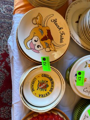 de nombreuses assiettes et bols posés sur une table, sur lesquels sont accrochées des étiquettes vertes