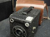 an old camera sitting on a table next to a suitcase