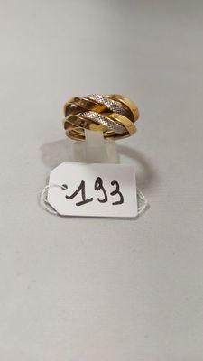 gros plan d'une bague sur une surface blanche avec une étiquette de prix