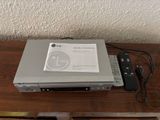 a dvd player sitting on a table with a remote next to it