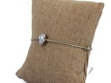 a small pillow with a button on it on a white background