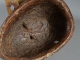 a brown bowl with a hole in it on a table