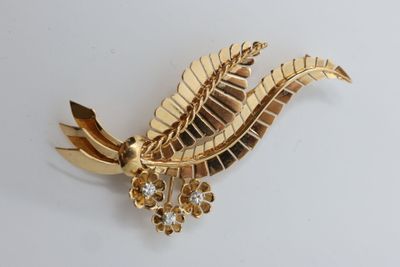 gold plated brooch with a leaf and flower design