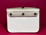 a white purse on a pink background