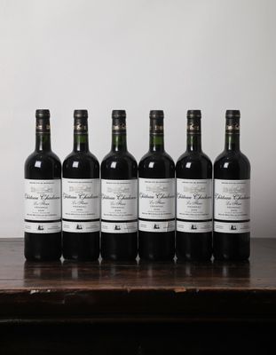 six bouteilles de vin sont alignées sur une table en bois