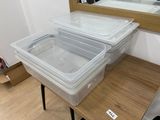 two plastic containers sitting on top of a wooden table