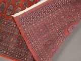 a close up of a red and blue rug on a gray surface