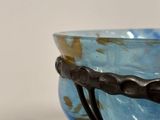 a blue bowl with a black handle on a table