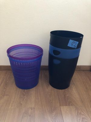 two trash cans sitting next to each other on the floor