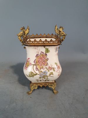 un vase avec un oiseau sur un support